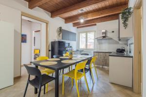 a kitchen and dining room with a table and yellow chairs at Villa Al Borgo - Villa with Private Garden in Salerno