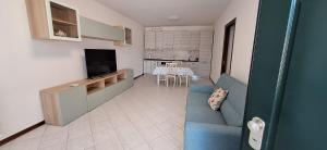 a living room with a blue couch and a kitchen at La casa di Aurora in Montopoli in Val dʼArno