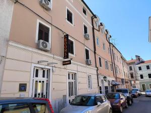 a building on a street with cars parked in front of it at Omir Bed & Breakfast in Pula