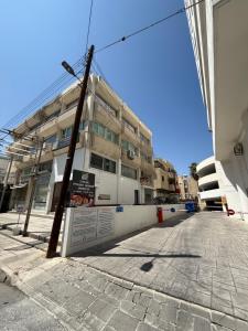 an empty street in front of a building at Kypa rooms 50 steps to the beach in Larnaca