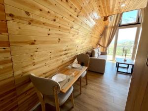 a dining room with a wooden wall at Doel House Zues - Hot Tub Villa & Scenic View in Shkodër +39 photos