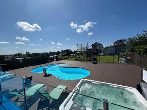 a swimming pool with chairs and a hot tub at Angelika in Swarzewo