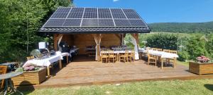 a gazebo with a solar roof with tables and chairs at Willa Golasówka in Muszyna