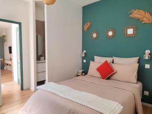 a bedroom with a large bed with a blue wall at L'Instant Vert in Clermont-Ferrand