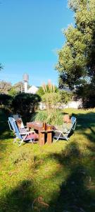 a picnic table and two chairs in the grass at Pura Vida Chapadmalal in Colonia Chapadmalal