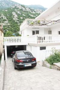 a car parked in a parking lot in front of a house at Asia Apartments in Škaljari