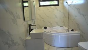 a bathroom with a white tub and a sink at Eco Elegance in Makho +28 photos