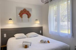 una camera da letto con due asciugamani su un letto con finestra di Villa Russie - Domaine Le Sherwood a Notre-Dame-de-Monts
