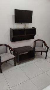 a living room with two chairs and a flat screen tv at Hotel Yogasthali - Top Rated !! Most Awarded !! Luxury Rooms !! Lift !! Parking in Rishīkesh