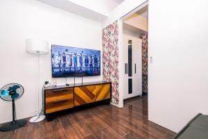 un salon avec une télévision à écran plat sur un mur dans l'établissement Suite Escape Luxe 1BR Makati condo Getaway Gym Swim Swim 2946 Fast MB, à Manille