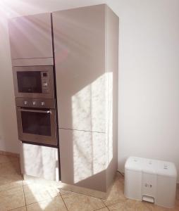 a kitchen with a stainless steel refrigerator and a microwave at Leohouse in Casarano