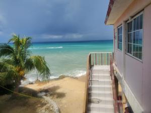 eine Treppe, die von einem Gebäude hinunter zu einem Strand führt in der Unterkunft EVELIN'S on the Beach in Montego Bay