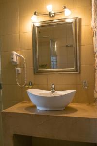 a bathroom with a white sink and a mirror at Kallisti Hotel in Potos