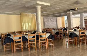 a dining room with tables and chairs with blue napkins at Hotel Il Gabbiano in Sanza