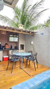 a table and chairs in a kitchen with a palm tree at Apt com piscina e sauna privativo em Milagres, Praia do Riacho in São Miguel dos Milagres