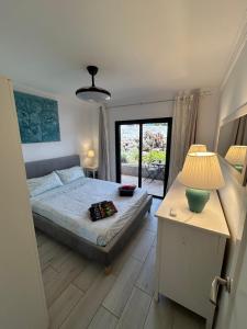 Un dormitorio con una cama y una mesa con una lámpara. en Marina Suite# Luxury Amarilla Golf, en San Miguel de Abona