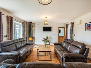 un soggiorno con mobili in pelle e un camino di Copper House a Willoughby