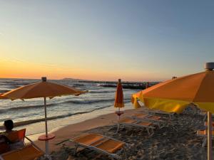 a group of chairs and umbrellas on a beach at Mali i Robit SeaView Apartment in Golem
