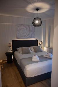 a bedroom with a large bed with two towels on it at KLA Luxury Boutique Suites by WESTBOOKING GR in Nikiana +95 photos
