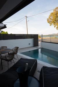 a swimming pool with a table and chairs on a patio at KLA Luxury Boutique Suites by WESTBOOKING GR in Nikiana