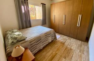 a bedroom with a bed and wooden cabinets at Sitio Boa Esperança II - 20km de Monte Verde in Camanducaia