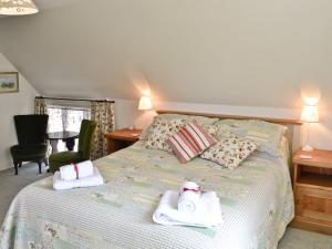 a bedroom with a bed with towels on it at Peartree Cottage in Northlew +9 photos