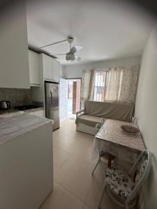 Una cocina y una sala de estar con una mesa y un sofá. en Seaside apartment, AV Atlantic, en Balneário Camboriú