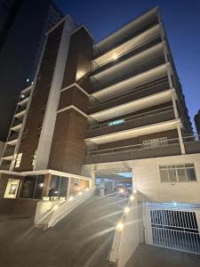Un edificio alto con una calle enfrente. en Seaside apartment, AV Atlantic, en Balneário Camboriú