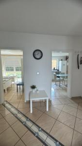 sala de estar con mesa y reloj en la pared en Ferienwohnung 2 mit Garten, en Hannover