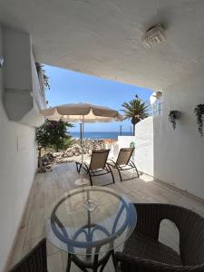 una mesa de cristal y sillas en un patio con vistas a la playa en Marina Suite# Luxury Amarilla Golf, en San Miguel de Abona