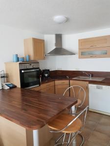 a kitchen with a wooden table and chairs at Appartement Melou rez de chaussée in Gérardmer