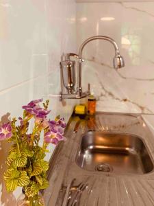 a vase of purple flowers sitting in a sink at Casa Indigo Blue Jeri in Jericoacoara