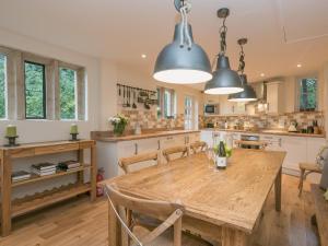 een keuken met een houten tafel en stoelen bij Hall Cottage in Brampton