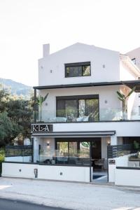 a white house with a sign that reads kaza at KLA Luxury Boutique Suites by WESTBOOKING GR in Nikiana