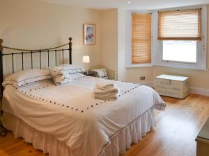 a bedroom with a large bed with towels on it at Tides Reach in Fowey