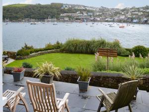a patio with chairs and a view of a body of water at Tides Reach in Fowey