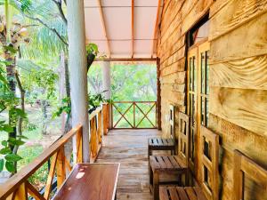 a porch of a house with a bench and a table at Osheen Homestay Sigiriya in Sigiriya