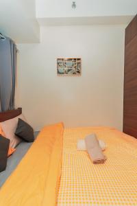 a bedroom with a yellow bed with towels on it at Urban Luxe 1BR Makati central gym swim Park Fast Internet MB 3301 in Manila