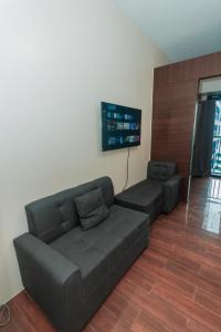 a living room with a couch and a flat screen tv at Urban Luxe 1BR Makati central gym swim Park Fast Internet MB 3301 in Manila