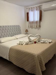 una camera da letto con due cigni che fanno un cuore su un letto di Marea a Palermo Altre 14 foto