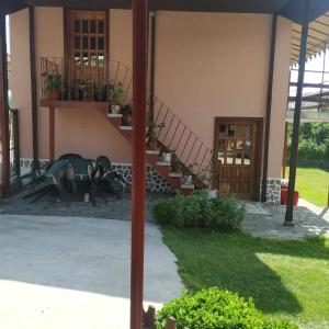 Un edificio con una mesa y unas escaleras y algunas plantas. en Villa Silvinka, en Dospat