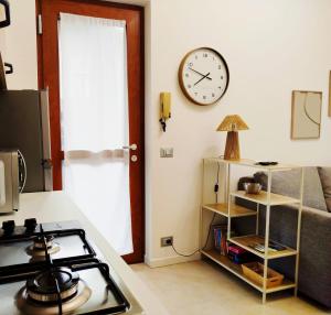 a kitchen with a stove and a clock on the wall at Holiday house in Rovetta