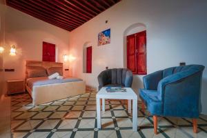 a bedroom with a bed and two chairs and a table at Dar Daarama in Chefchaouene
