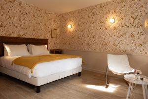 a bedroom with a bed and a table and a chair at Le Clos du Château in Amboise