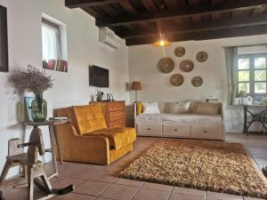 a living room with a couch and a chair at Kelepelő Porta in Poroszló