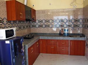 a kitchen with wooden cabinets and a blue refrigerator at Anand Valley View Apartment in Nākuri