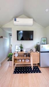 a kitchen with a counter with a refrigerator and a tv at บ้านไร่ฟ้าสวยวังน้ำเขียว Little House in Ban Khlong Ta Sang