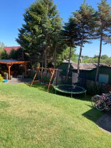a backyard with a trampoline in the grass at Sielska Chatka in Sarbinowo +5 photos