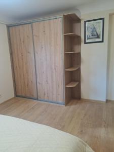 a bedroom with a wooden closet and a book shelf at Sea nest in Jūrmala