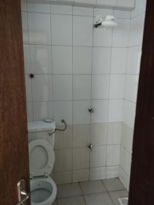 a bathroom with a toilet in a tiled room at Qwetu in Thika